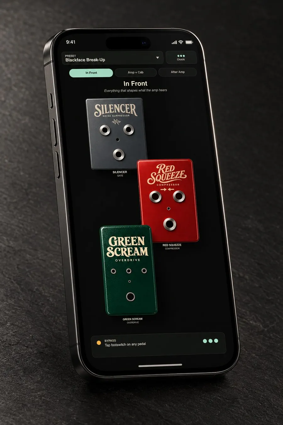 An iPhone held in one hand, showing a RigShed drive pedal with three knobs and a lit indicator LED, with two more pedals stacked beneath it